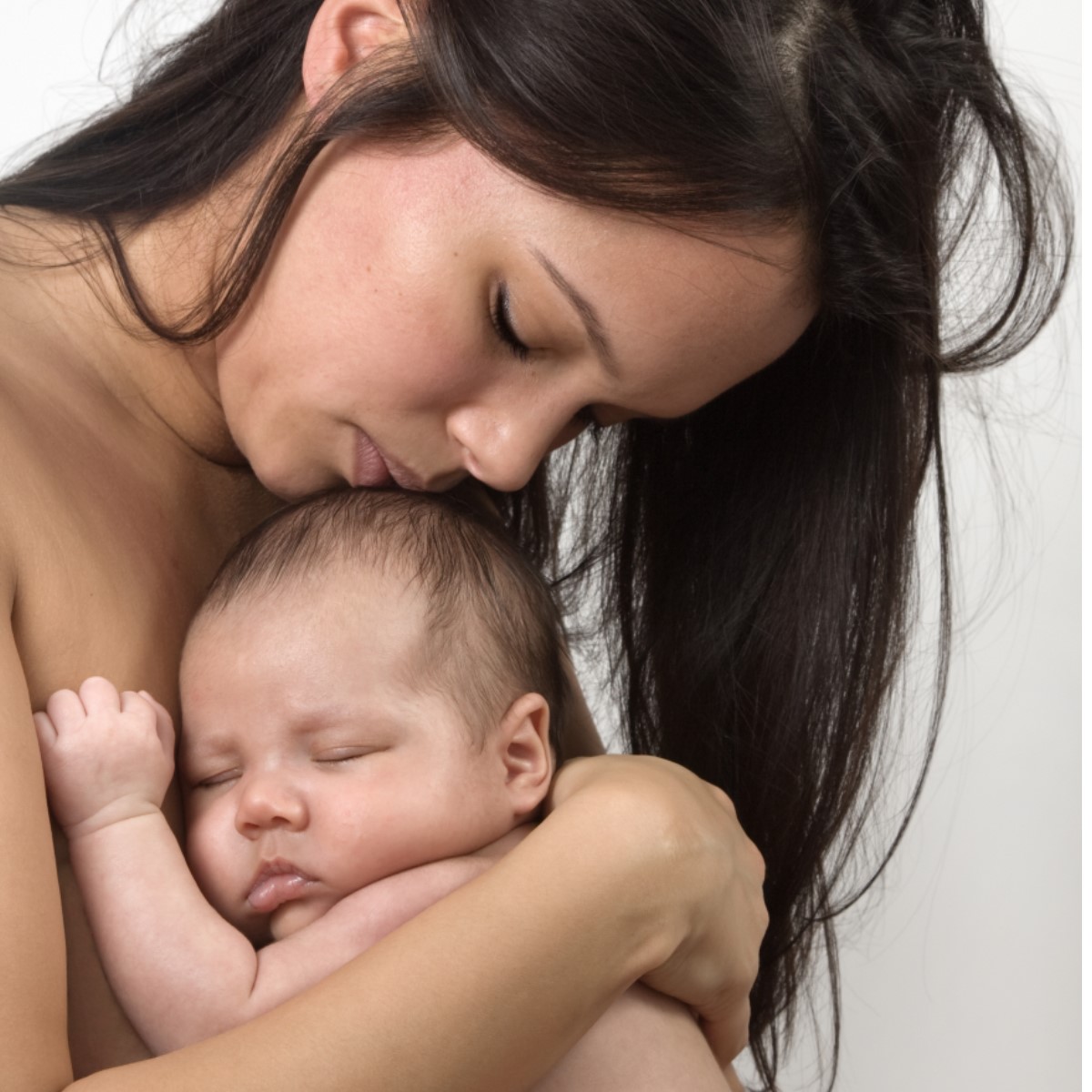 Person holding their infant close skin to skin